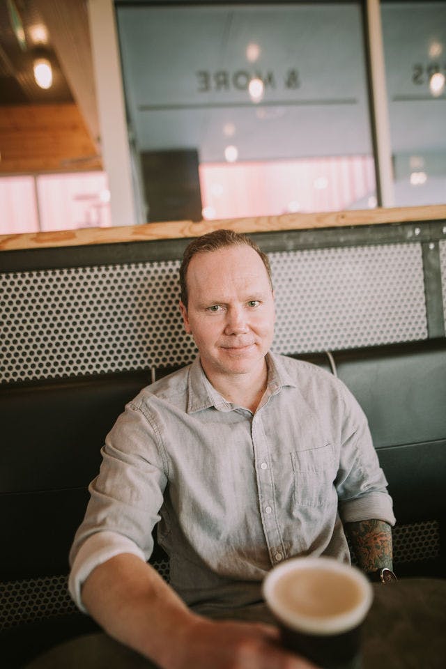 Dating profile photo with coffee, taken by The Match Artist