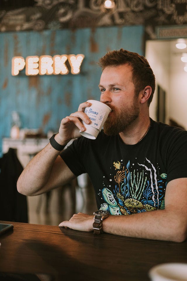 Dating profile photo with coffee, taken by The Match Artist